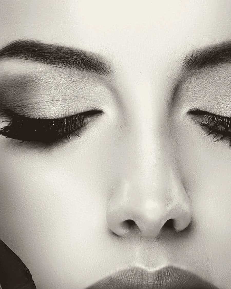 A close study of closed eyes with defined brows and a drawn liner